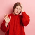women in a red outfits having headaches want to know how to stop a headache (Migraine)
